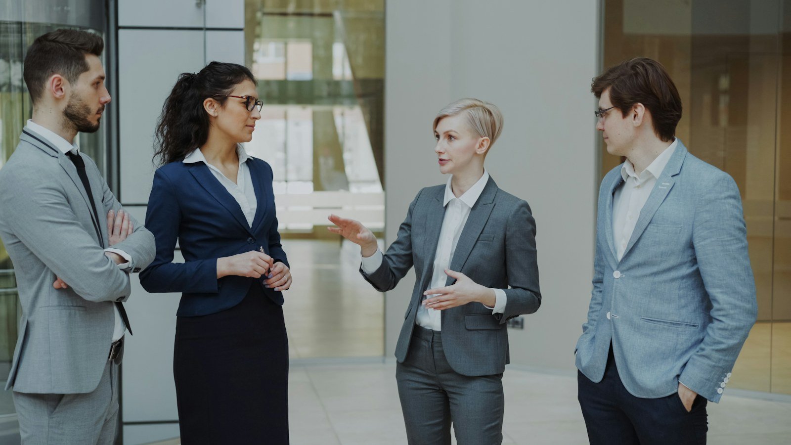 Four professionals discussing their work together in an office.